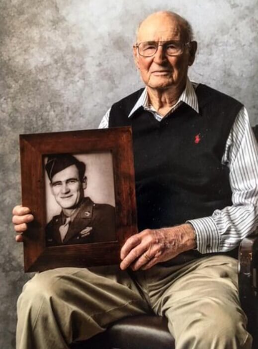 kinney holding photo of himself as a younger soldier national ranger memorial
